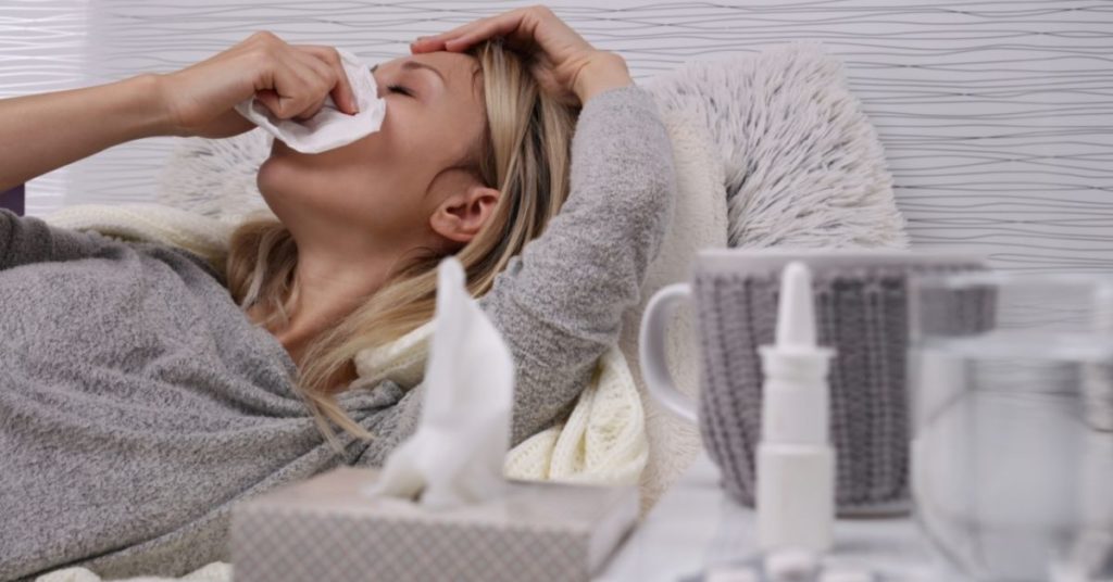 Woman resting at home with flu symptoms in Neath